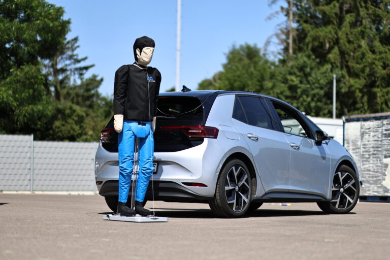 Pedestrian dummy next to a test vehicle